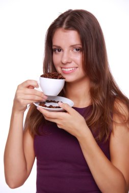 bir fincan kahve çekirdekleri tutan genç kadın