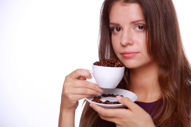 bir fincan kahve çekirdekleri tutan genç kadın