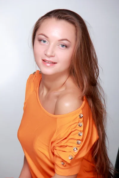 Schönes Mädchen im orangefarbenen Kleid — Stockfoto