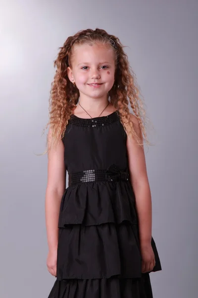 Kleines Mädchen in einem schwarzen Kleid — Stockfoto