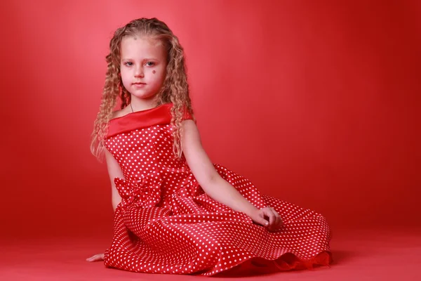 Liten flicka i en prickiga klänning — Stockfoto