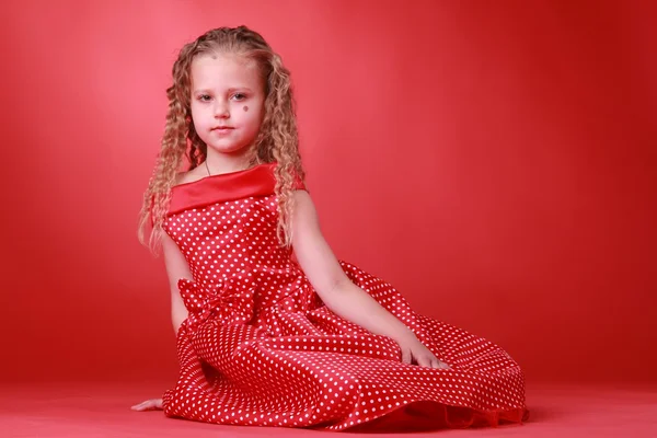 Kleines süßes Mädchen in einem gepunkteten Kleid — Stockfoto