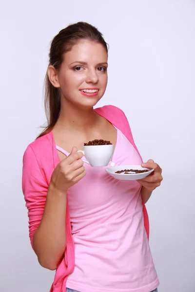 Junge Frau mit einer Tasse Kaffeebohnen — Stockfoto