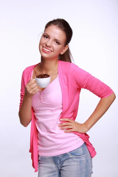 Jovem segurando uma xícara de grãos de café — Fotografia de Stock