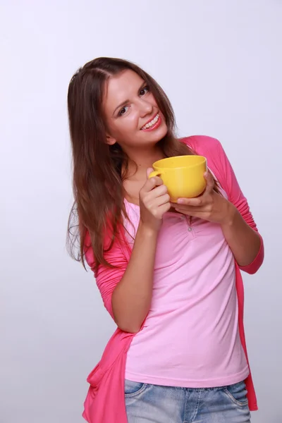 Mujer joven sosteniendo taza de té amarillo — Foto de Stock