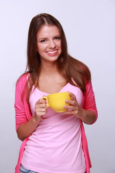 Mujer joven sosteniendo taza de té amarillo — Foto de Stock