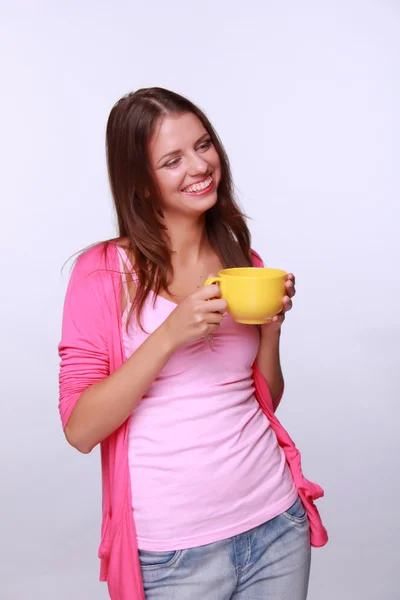 Mujer joven sosteniendo taza de té amarillo — Foto de Stock