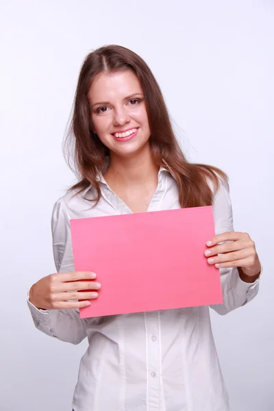 Bruneta s doklad na růžovém papíru ve svých rukou — Stock fotografie