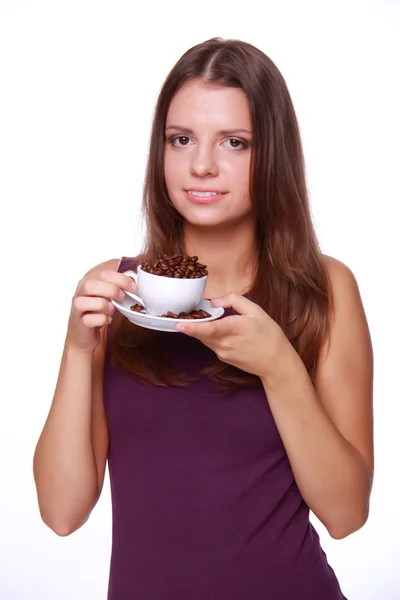 Mujer joven sosteniendo una taza de granos de café — Foto de Stock