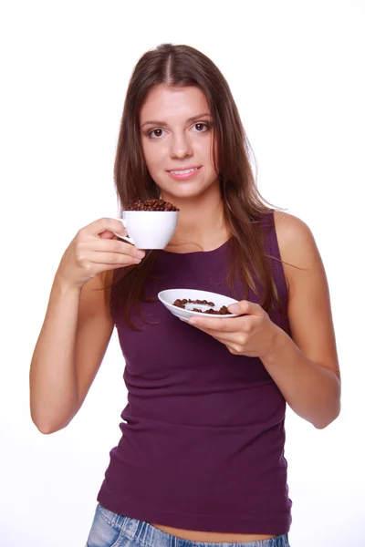 Mujer joven sosteniendo una taza de granos de café — Foto de Stock