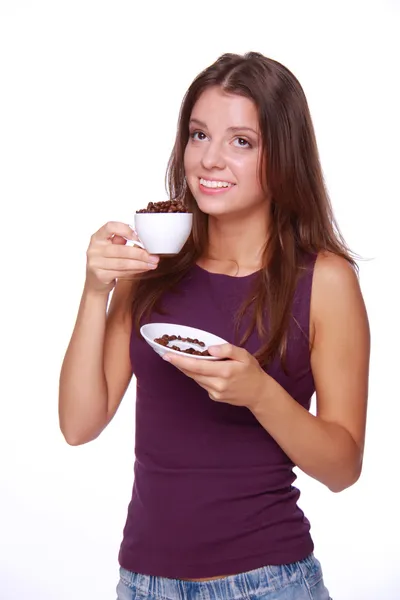 Mujer joven sosteniendo una taza de granos de café — Foto de Stock