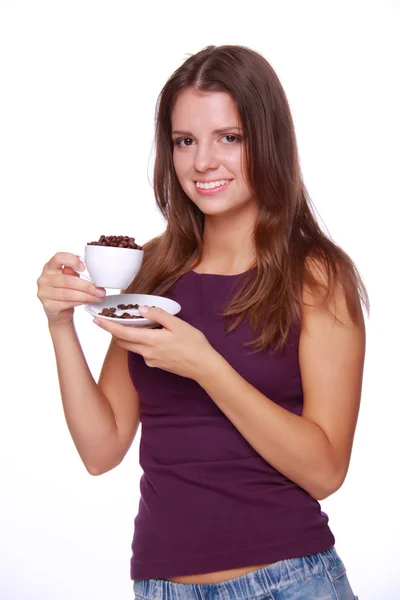 Mujer joven sosteniendo una taza de granos de café — Foto de Stock