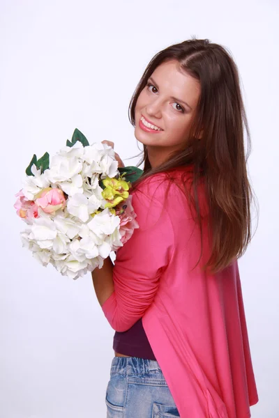 Mooie brunette in een roze blouse met een boeket — Stockfoto