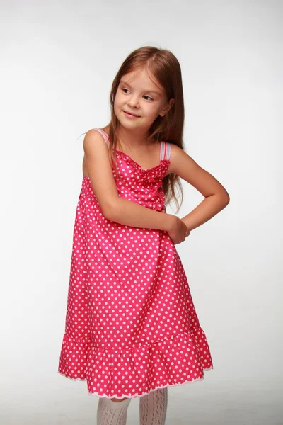 Mooi meisje in een roze jurk met noppen — Stockfoto