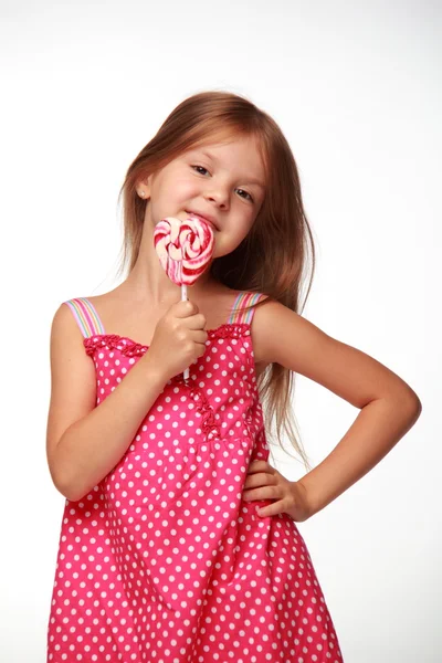Little girl in pink dress with lollipop — Stock Photo, Image