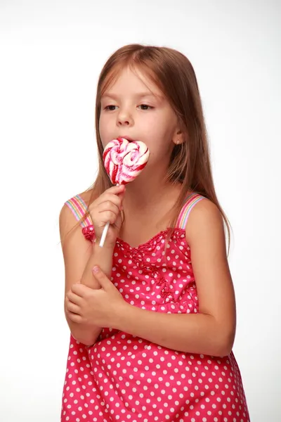 Niña en vestido rosa con piruleta — Foto de Stock