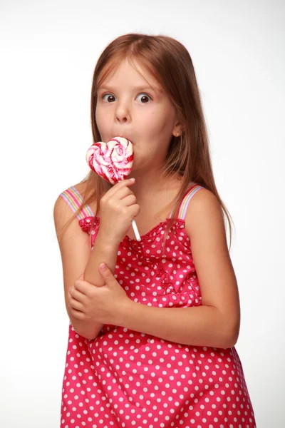 Niña en vestido rosa con piruleta —  Fotos de Stock