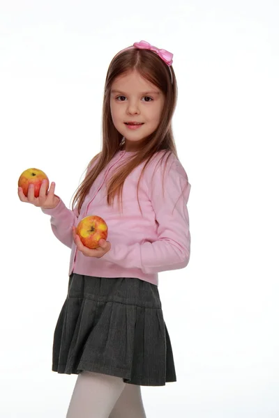 Liten flicka anläggning två äpplen — Stockfoto