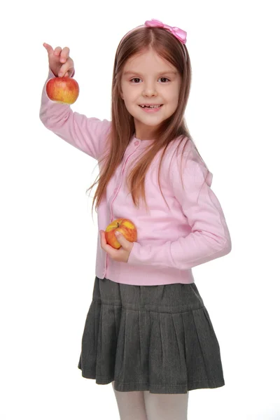 Liten flicka anläggning två äpplen — Stockfoto