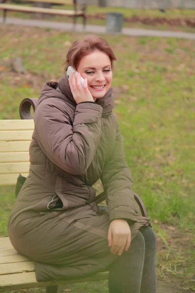 Kobieta w parku rozmawia przez telefon — Zdjęcie stockowe