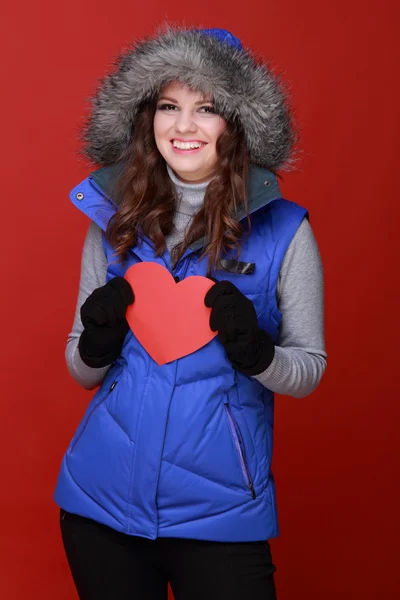 Chica cálidamente vestida con un corazón en sus manos —  Fotos de Stock