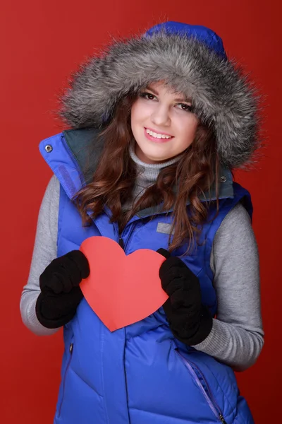 Warm gekleed meisje met een hart in zijn handen — Stockfoto