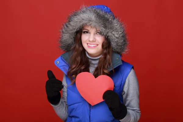 Chica cálidamente vestida con un corazón en sus manos —  Fotos de Stock