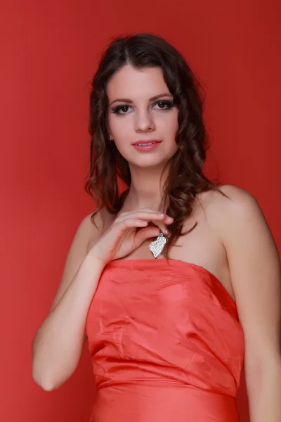 Brunette with a silver heart in the hands — Stock Photo, Image