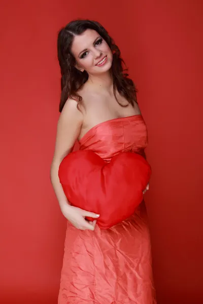 Girl in red dress with symbol of heart — Stock Photo, Image