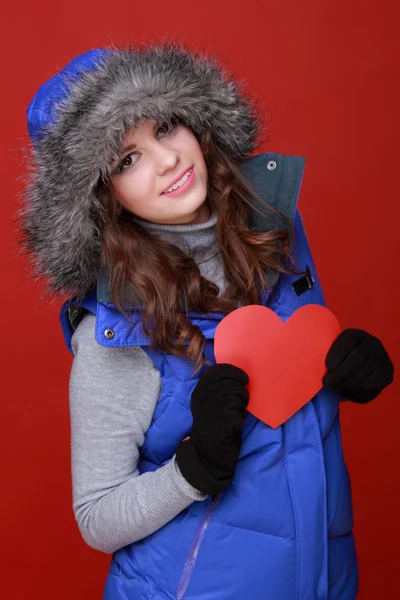 Warm gekleed meisje met een hart in zijn handen — Stockfoto