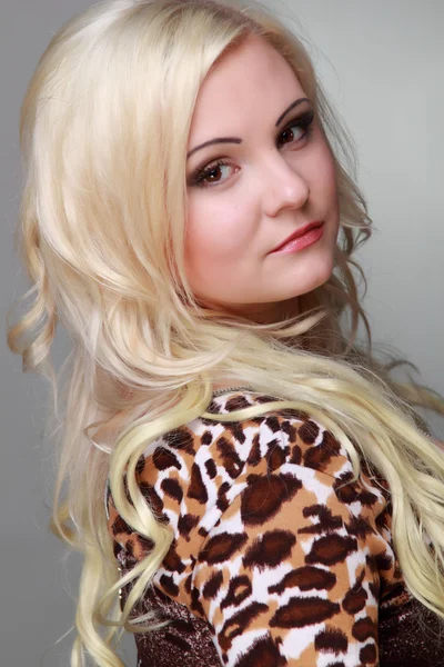 Schöne Mädchen mit langen blonden Haaren trägt sexy Leopardenkleid — Stockfoto