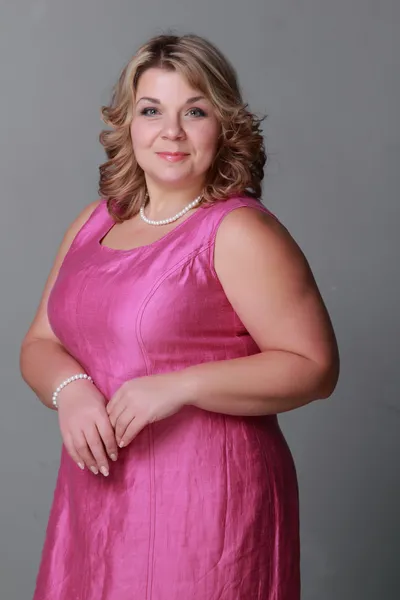 Schöne Frau in einem rosa Kleid — Stockfoto