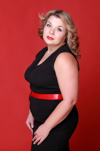 Retrato de uma mulher bonita em um fundo vermelho — Fotografia de Stock