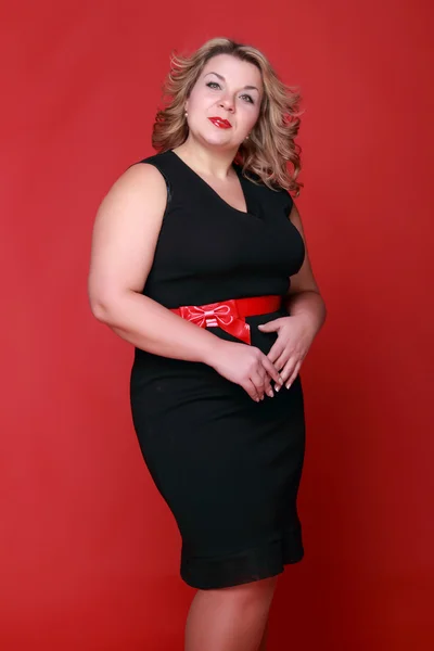 Retrato de uma mulher bonita em um fundo vermelho — Fotografia de Stock