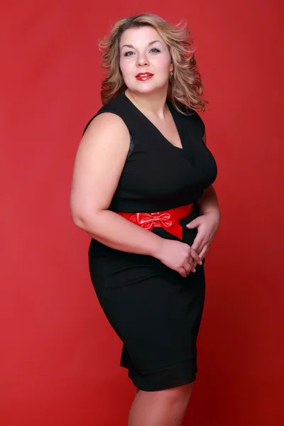 Retrato de uma mulher bonita em um fundo vermelho — Fotografia de Stock