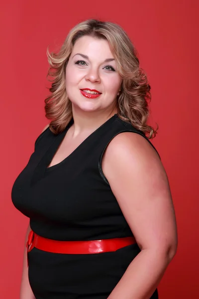 Retrato de uma mulher bonita em um fundo vermelho — Fotografia de Stock