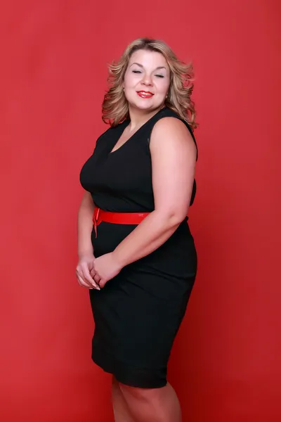 Retrato de uma mulher bonita em um fundo vermelho — Fotografia de Stock