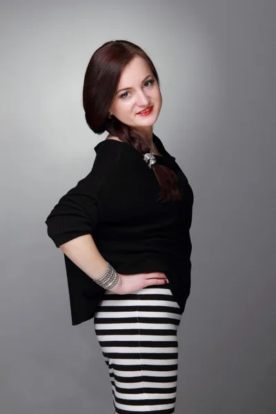 Portret van een mooi meisje in een gestreepte rok — Stockfoto