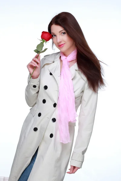 Menina em um casaco branco segurando uma bela rosa — Fotografia de Stock