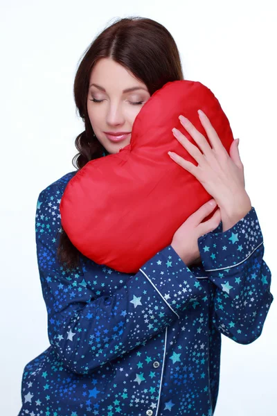 Girl with heart shape pillow — Stock Photo, Image