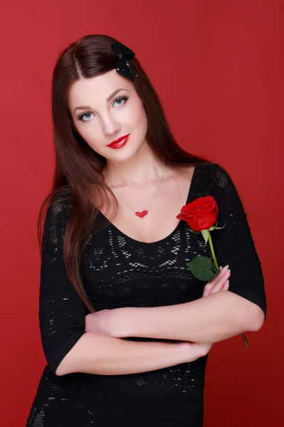 Ragazza con una rosa su uno sfondo rosso — Foto Stock