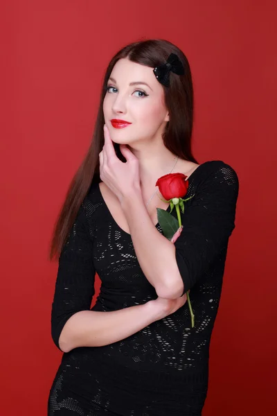 Dziewczyna z różą na czerwonym tle — Zdjęcie stockowe