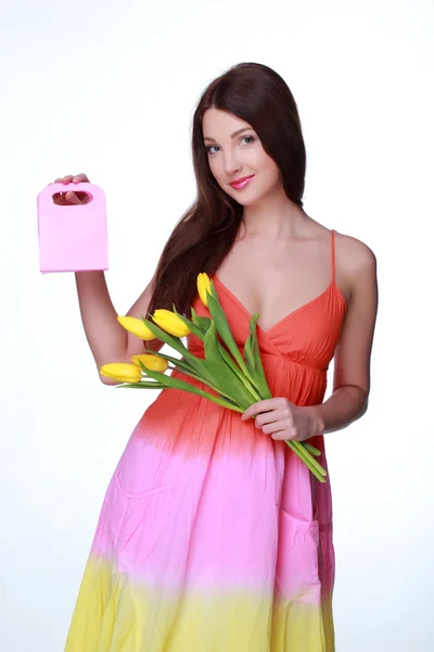 Gelukkig meisje met gele tulpen en gift — Stockfoto