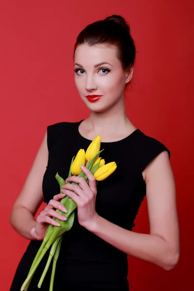 Europäische junge Frau hält schöne frische Tulpen zum Thema Urlaub — Stockfoto