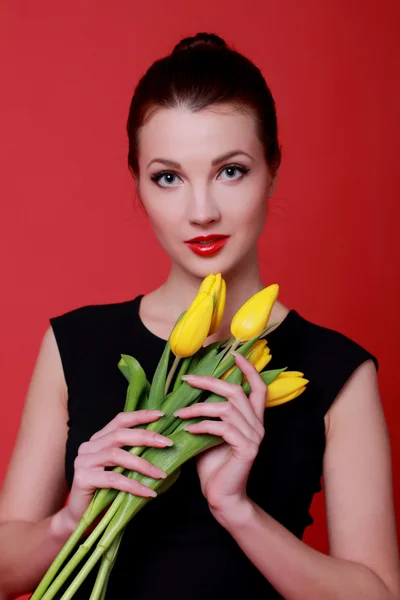 Europäische junge Frau hält schöne frische Tulpen zum Thema Urlaub — Stockfoto