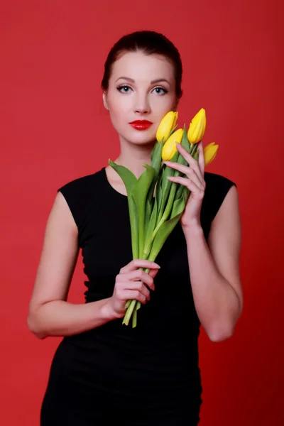 Beautiful girl with yellow tulips — Stock Photo, Image