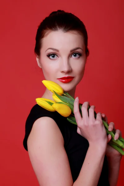 Hermosa chica con tulipanes amarillos — Foto de Stock