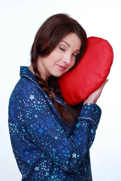 Picture of happy and smiling woman with heart-shaped pillow Stock Picture