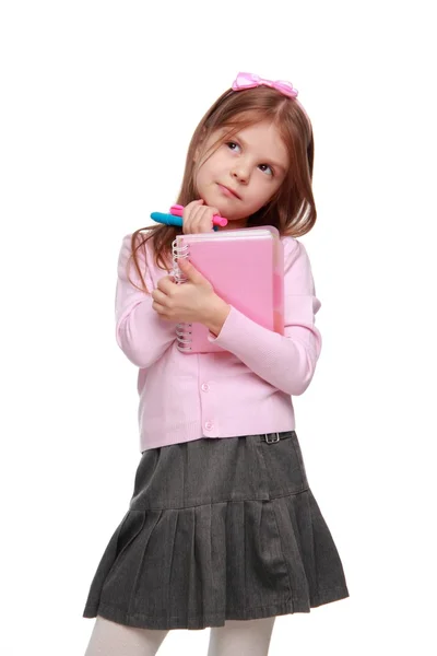 Pequeña colegiala sosteniendo lápices de colores y libro de copias — Foto de Stock