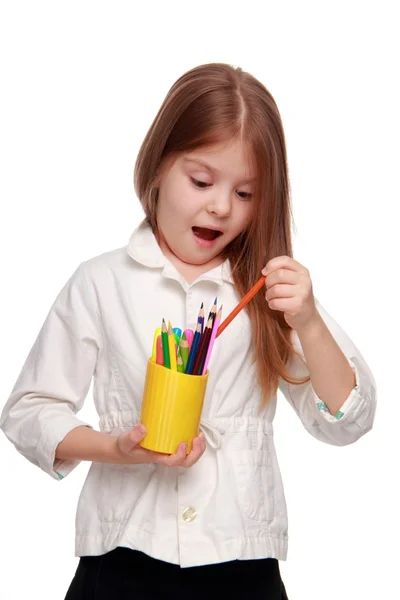 Маленькая школьница с карандашами — стоковое фото
